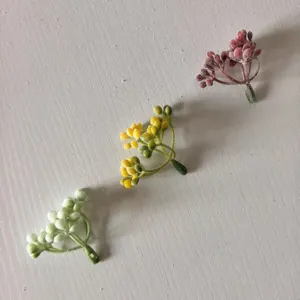 Detail view of flocked artificial berry branches, perfect for DIY garlands and crafts.