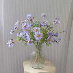 Artificial purple cosmos flowers in clear glass vase, elegant floral decor for home.