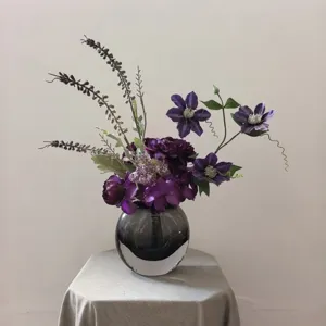 Arrangement de fleurs de clématite violette artificielle en vase en verre pour décoration de mariage