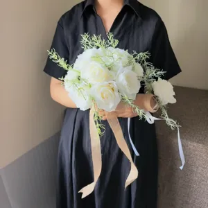 Bouquet de mariée artificiel de roses blanches avec feuillage vert et ruban de jute rustique.