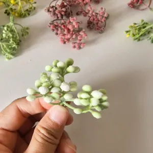 Close up of flocked artificial berry twig, perfect for DIY wreaths and floral craft decor.