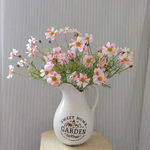 Artificial cosmos flowers in white ceramic vase, beautiful floral arrangement for home decor.
