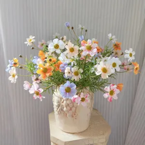 Detailed close-up of artificial cosmos and daisy bouquet, pastel silk flowers for home decor.