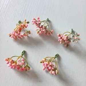 Close-up detail view of pink flocked berry branches, perfect for DIY garlands and crafts.