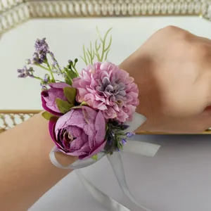 Detail shot of purple artificial flower wrist corsage with ribbon for wedding party.