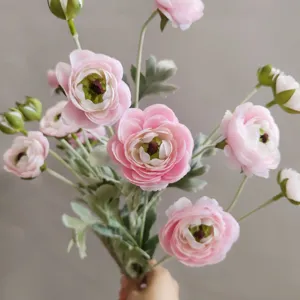 Detailansicht des rosa geflockten künstlichen Hahnenfuss Blumenstrausses mit sechs Köpfen.
