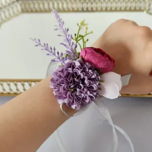 Purple artificial wrist corsage detail shot, featuring fabric flowers and silver ribbons.