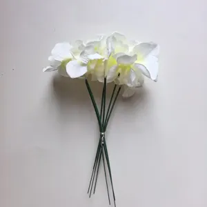 Primer plano detallado de ramo de flores artificiales blancas con tallos verdes para decoración.