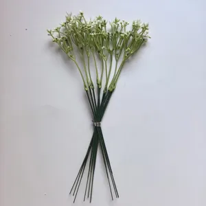 Primer plano detallado de flores blancas artificiales con tallos verdes para decoración DIY.