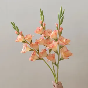 Close-up detail shot of artificial gladiolus flower stem, peach pink gradient petals for decor.