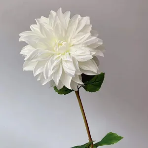 Close-up detail of white artificial dahlia flower head with green leaf and stem decor.