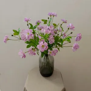 Künstlicher rosa Ranunkeln Blumenstrauß in Glasvase für Heimdekoration DIY Gestaltung.