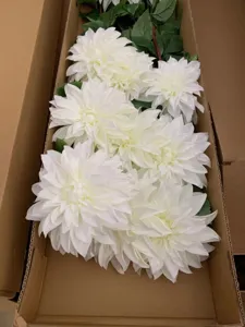 Detailed close-up view of large artificial white dahlia flowers neatly packed in cardboard box.