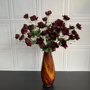 Bouquet di fiori artificiali di anemoni rosso scuro in vaso marrone per decorazioni domestiche.