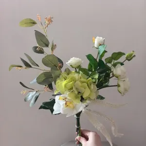 Détail de bouquet de fleurs artificielles blanc et vert, eucalyptus et roses, déco de maison.