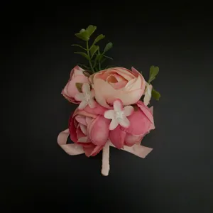 Pink artificial flower boutonniere close-up detail for wedding groom and photography props.