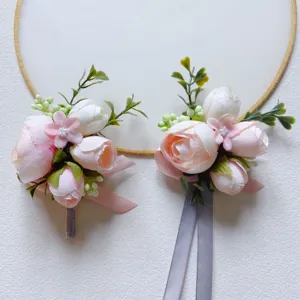 Exquisite artificial wedding boutonnieres with pink and white flowers for grooms and groomsmen.