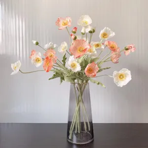 Artificial Icelandic poppy flower bouquet in glass vase, coral pink and white faux silk flowers.