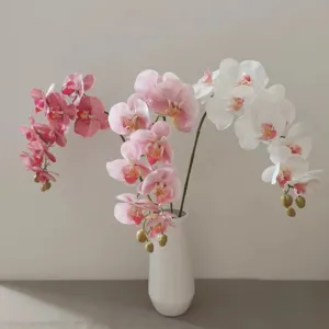 Artificial Phalaenopsis orchids in white ceramic vase, realistic fake flowers for home decor