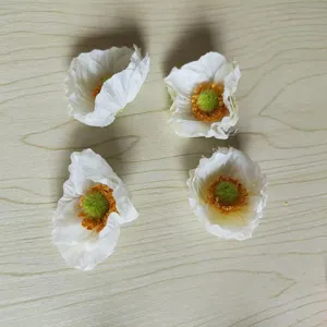 Detailed view of white artificial poppy flower heads, perfect for DIY hair accessories and crafts.