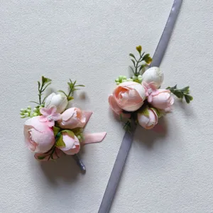 Detail shot of artificial pink and white flower wrist corsage and boutonniere with ribbons.