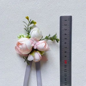 Artificial flower boutonniere in light pink and white with grey ribbons for wedding grooms.