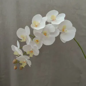 Detailed close-up view of artificial white phalaenopsis orchid branch floral decor