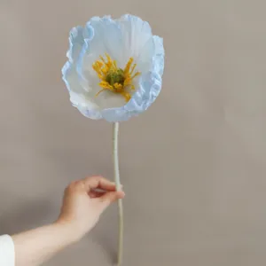 Primo piano dettagliato del fiore di papavero artificiale con delicati petali blu e bianchi.