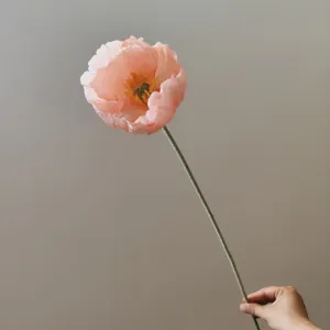 Primo piano di un fiore di papavero rosa artificiale su stelo lungo, elegante decoro.