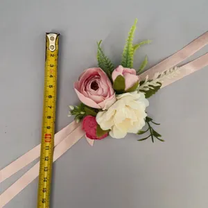 Artificial rose wrist flower with ribbon, pink wedding corsage detail display for bridal party.