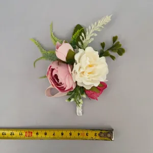 Artificial flower corsage detail shot showing floral arrangement size with a measuring tape.