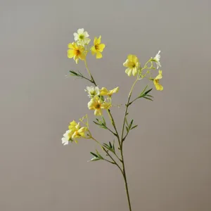 Detailed close-up of artificial yellow and white clematis flower branch for home decor.