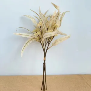 Vue détaillée d'un bouquet d'eucalyptus artificiel avec de longues feuilles et de petites baies.