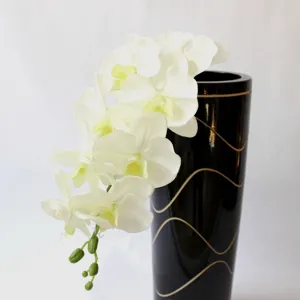 Scatto dettagliato di ramo di fiore di orchidea phalaenopsis artificiale bianca con vaso.