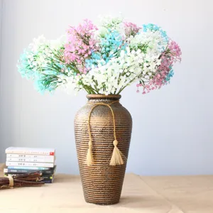 Bouquet di fiori di gipsofila artificiali con vaso marrone texturizzato per decorazioni.