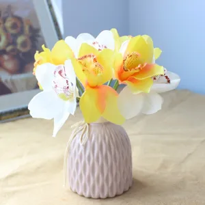 Artificial silk orchid flower bouquet in pink ceramic vase for elegant home decor design.