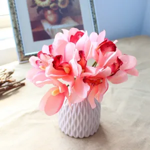 Artificial silk cymbidium orchid bouquet in a stylish ribbed vase for home decor.