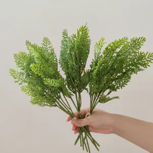 Artificial fern plant branch detail shot, vibrant green plastic leaves for home decor floral.