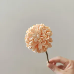 Vista di dettaglio di un singolo fiore di seta di crisantemo pompon artificiale per decoro.