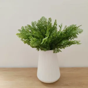 Artificial fern plant in white ribbed vase, perfect desktop decor for home or wedding.