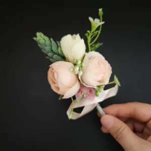 Gedetailleerd overzicht van de elegante lichtroze kunstmatige rozen boutonnière voor bruiloften.