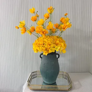 Bouquet de fleurs artificielles jaunes avec vase sombre vintage et plateau doré pour déco détail