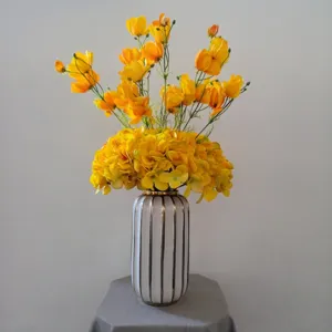 Bouquet de fleurs artificielles jaunes avec vase en céramique pour déco de table salon.