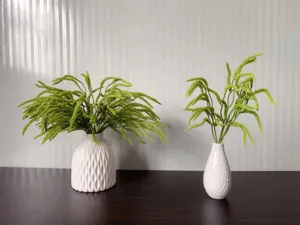 Artificial green plant decoration with white textured ceramic vase for home interior detail