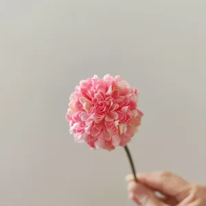 Primo piano dettagliato della testa di fiore di crisantemo artificiale rosa con petali morbidi.