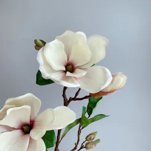 Detailaufnahme eines künstlichen Magnolienblütenzweigs mit realistischen Blütenblättern.