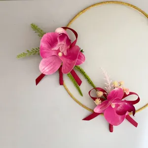 Vista dettagliata della boutonnieres orchidea rosa con nastro rosso per sposo e matrimoni.