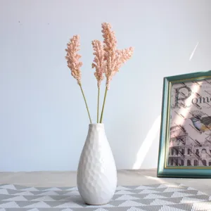 Charming pink artificial foam flower bouquet in white ceramic vase for home decor.