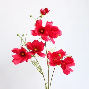 Gros plan détaillé de fleurs de cosmos artificielles rouges vibrantes pour la décoration.
