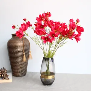 Détail de fleurs de cosmos artificielles, arrangement floral en soie rouge vif pour décor.